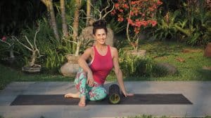 Elaine Reynolds Master Personal Trainer sitting on yoga mat with her roller