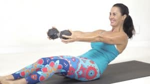 Ab exercise on the mat holding a dumbbell