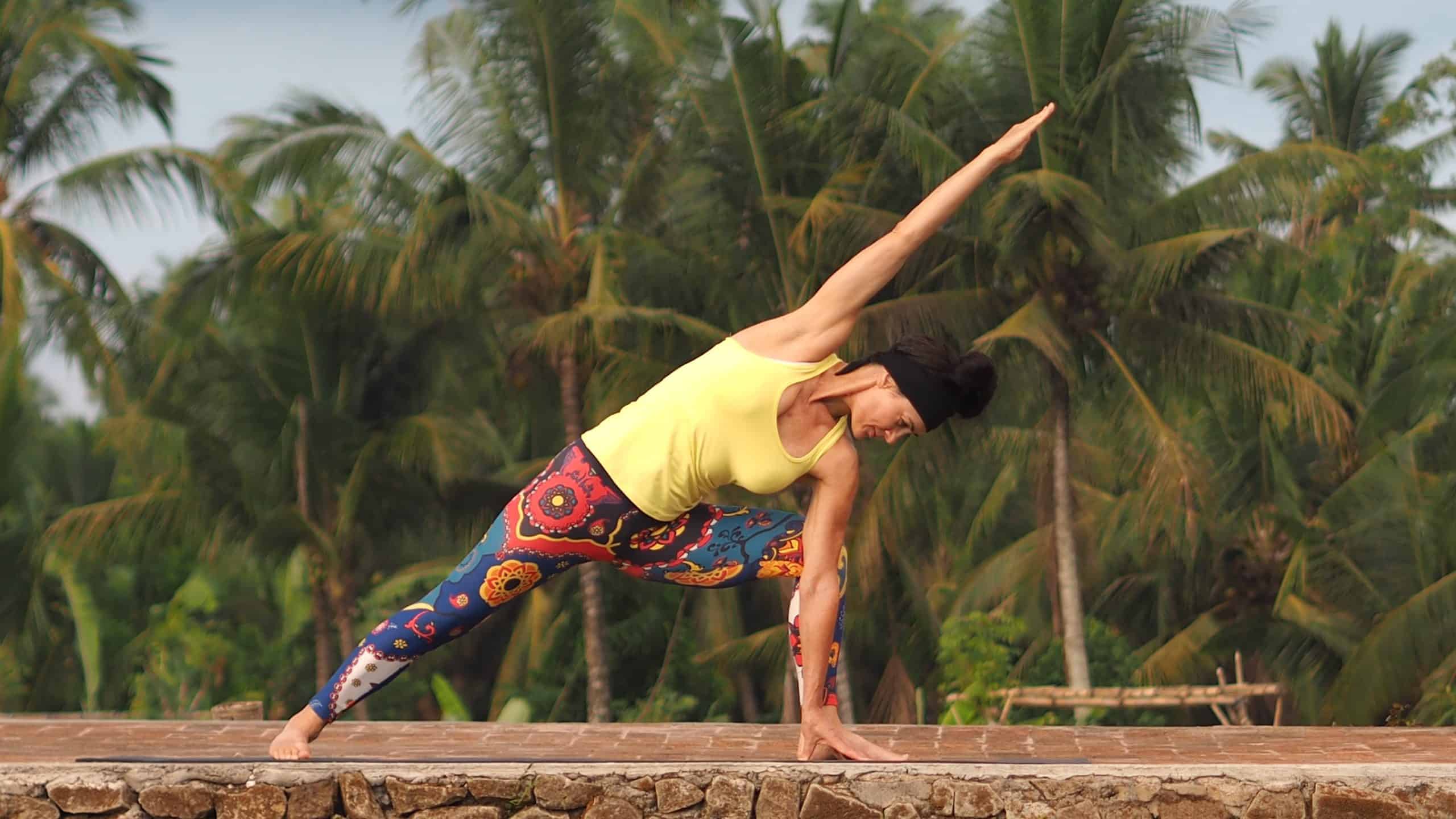 Elaine Reynolds Master Personal Trainer doing side angle pose with jungle background